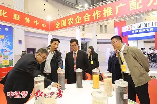 全國農技推廣中心副主任謝建華、全國農技推廣中心土肥處處長辛景樹仔細研究紅四方新型肥料。